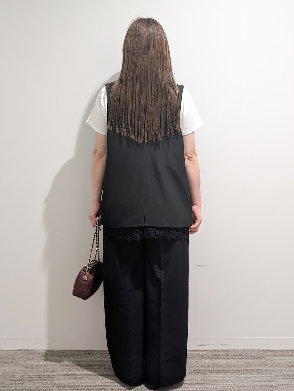 ブラック系のベスト、ホワイト系のTシャツ/カットソー、ブラック系のその他パンツを着用したレディースの秋コーディネートの5枚目の写真