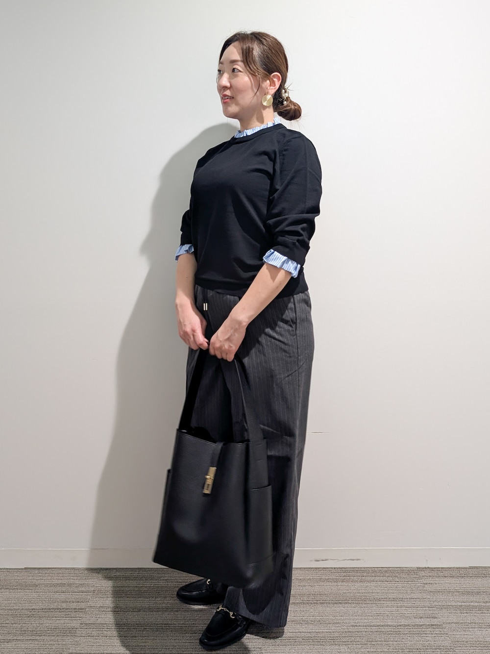 ブラック系のニット/セーター、グレー系のその他パンツ、ブラック系のトートバッグを着用したレディースの秋コーディネートの7枚目の写真