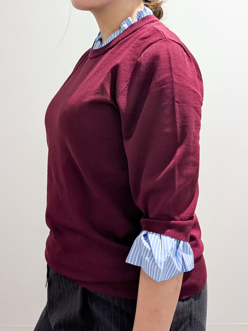 レッド系のニット/セーター、グレー系のその他パンツ、ブラック系のトートバッグを着用したレディースの秋コーディネートの6枚目の写真