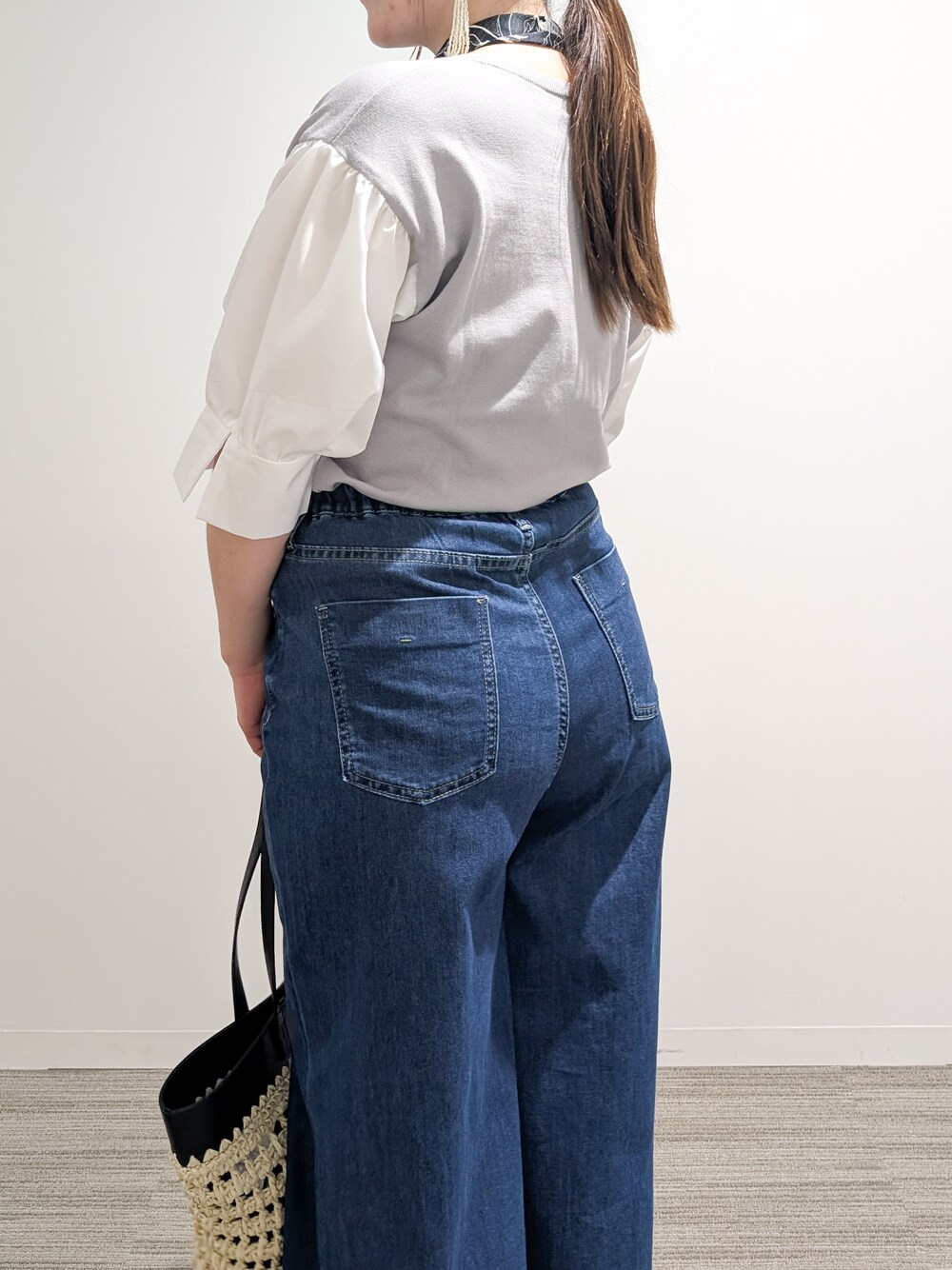 グレー系のニット/セーター、ブルー系のデニムパンツ、ブラック系のトートバッグを着用したレディースの夏コーディネートの7枚目の写真