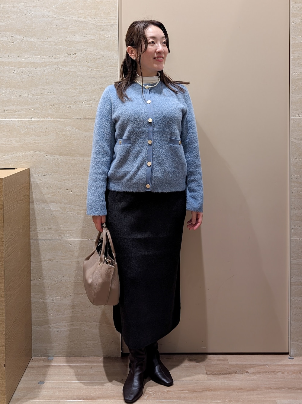 ブルー系のカーディガン/ボレロ、グレー系のスカート、ベージュ系のトートバッグを着用したレディースの秋コーディネートの8枚目の写真