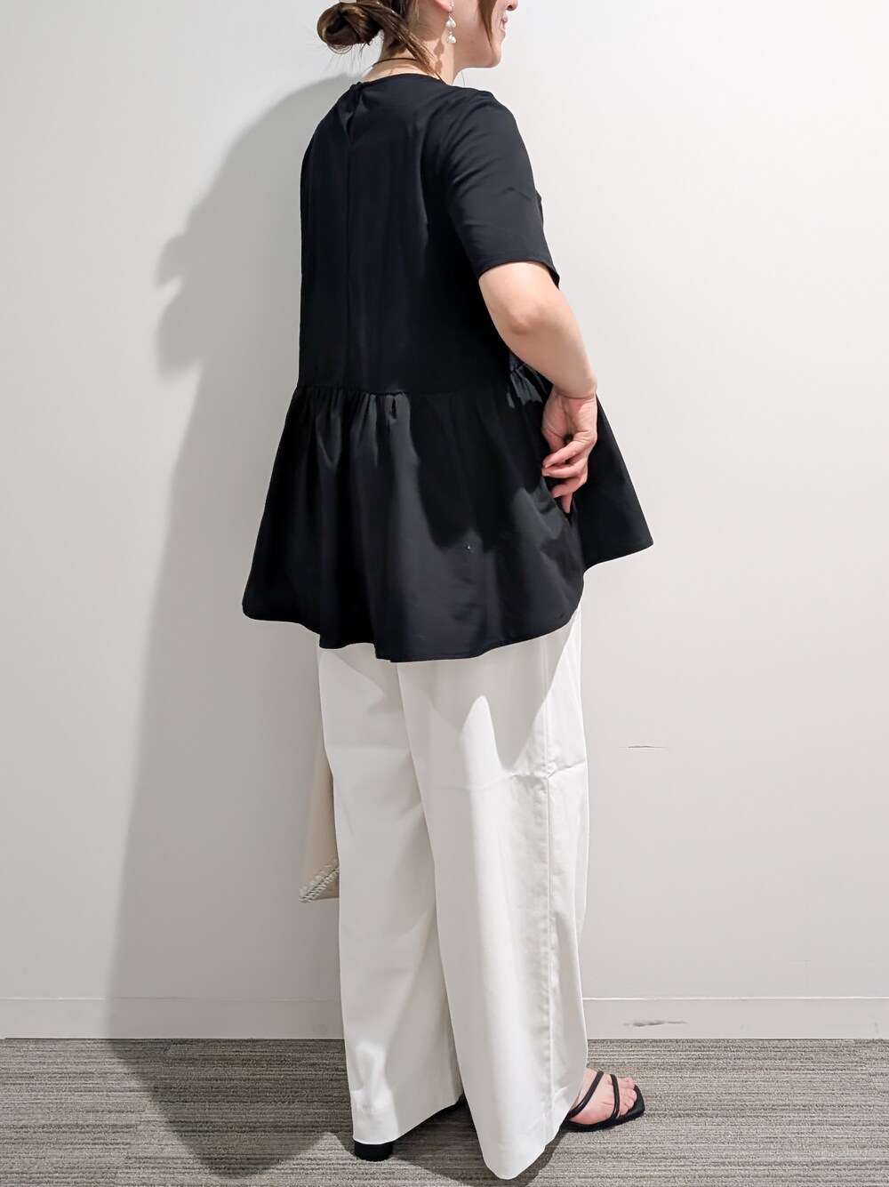 ブラック系のTシャツ/カットソー、ホワイト系のその他パンツ、ホワイト系のハンドバッグを着用したレディースの夏コーディネートの5枚目の写真