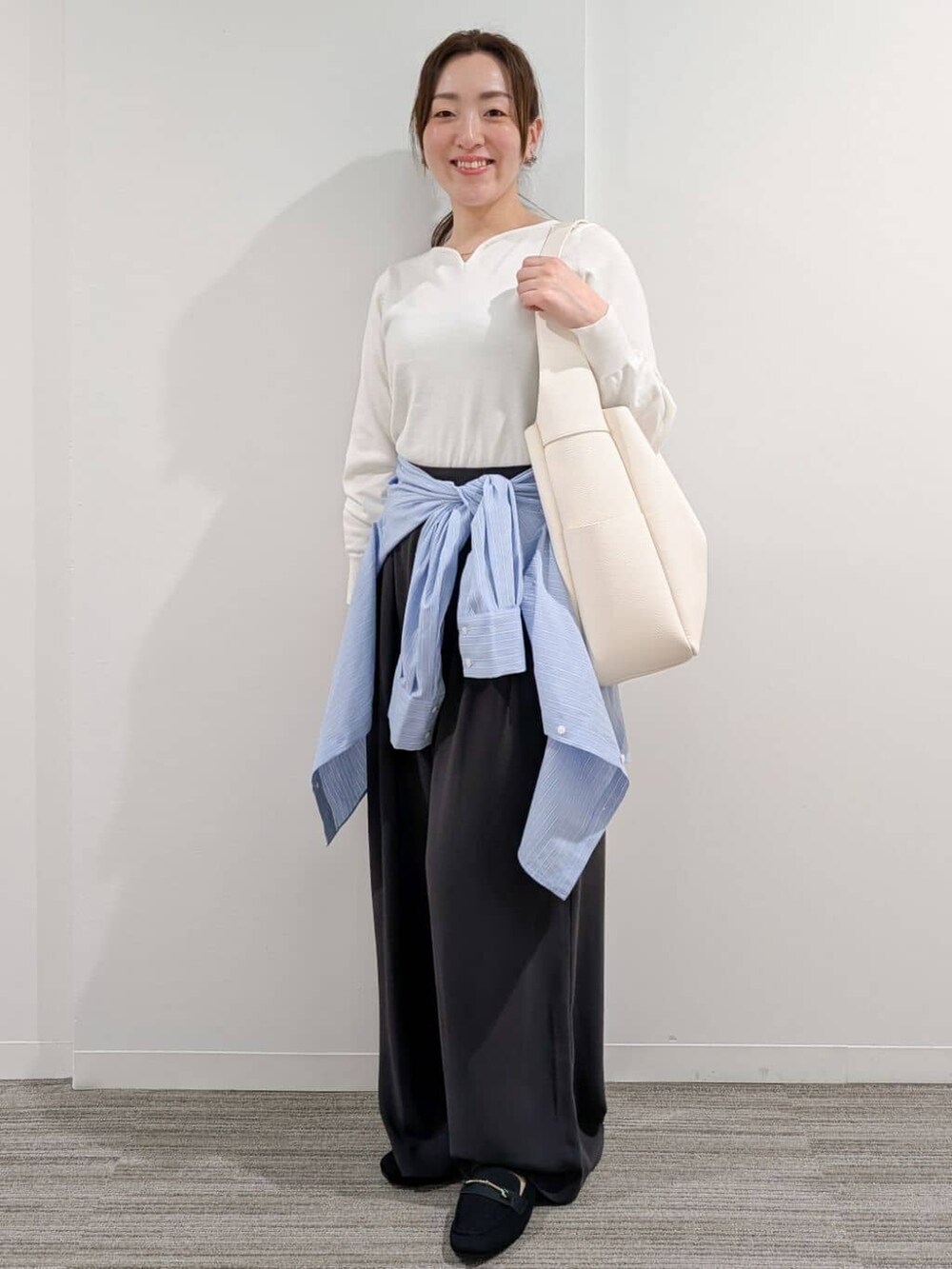 ブルー系のシャツ/ブラウス、ホワイト系のニット/セーター、グレー系のその他パンツを着用したレディースの冬コーディネートの8枚目の写真