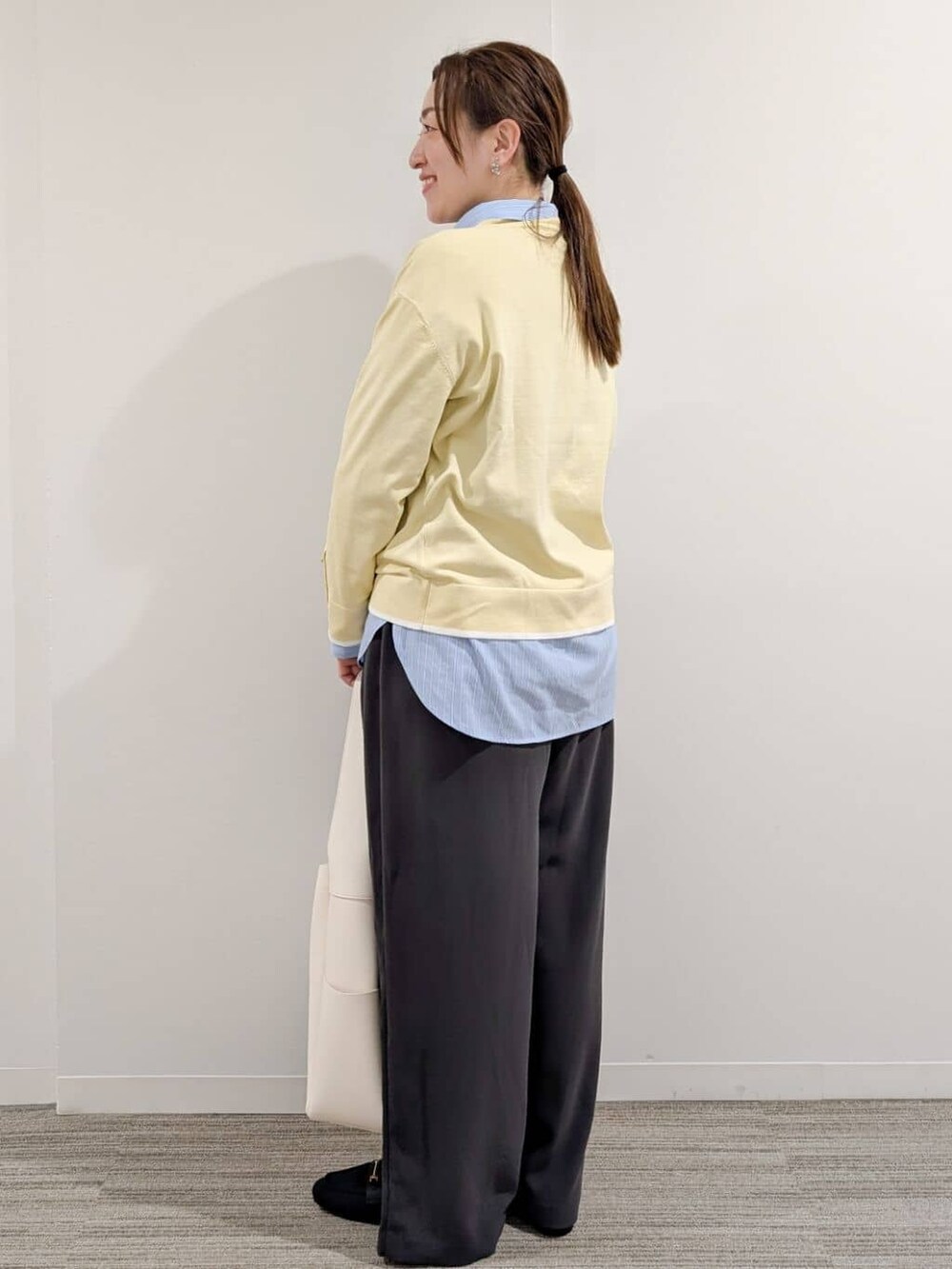 イエロー系のニット/セーター、ブルー系のシャツ/ブラウス、グレー系のその他パンツを着用したレディースの冬コーディネートの5枚目の写真