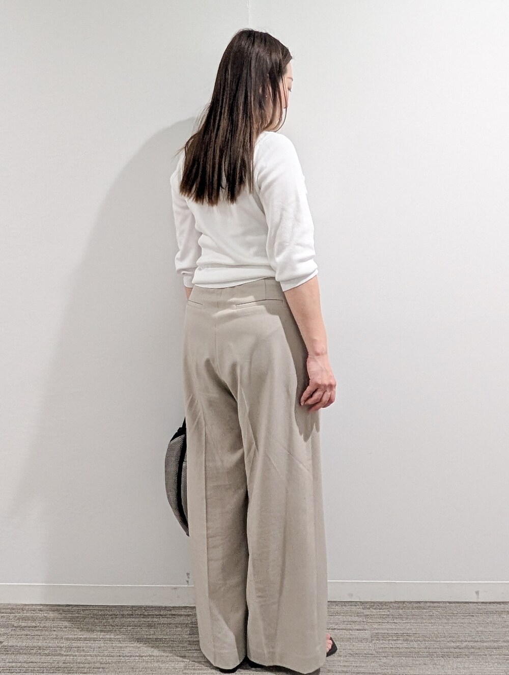 ホワイト系のニット/セーター、ベージュ系のその他パンツ、グレー系のトートバッグを着用したレディースの春コーディネートの7枚目の写真