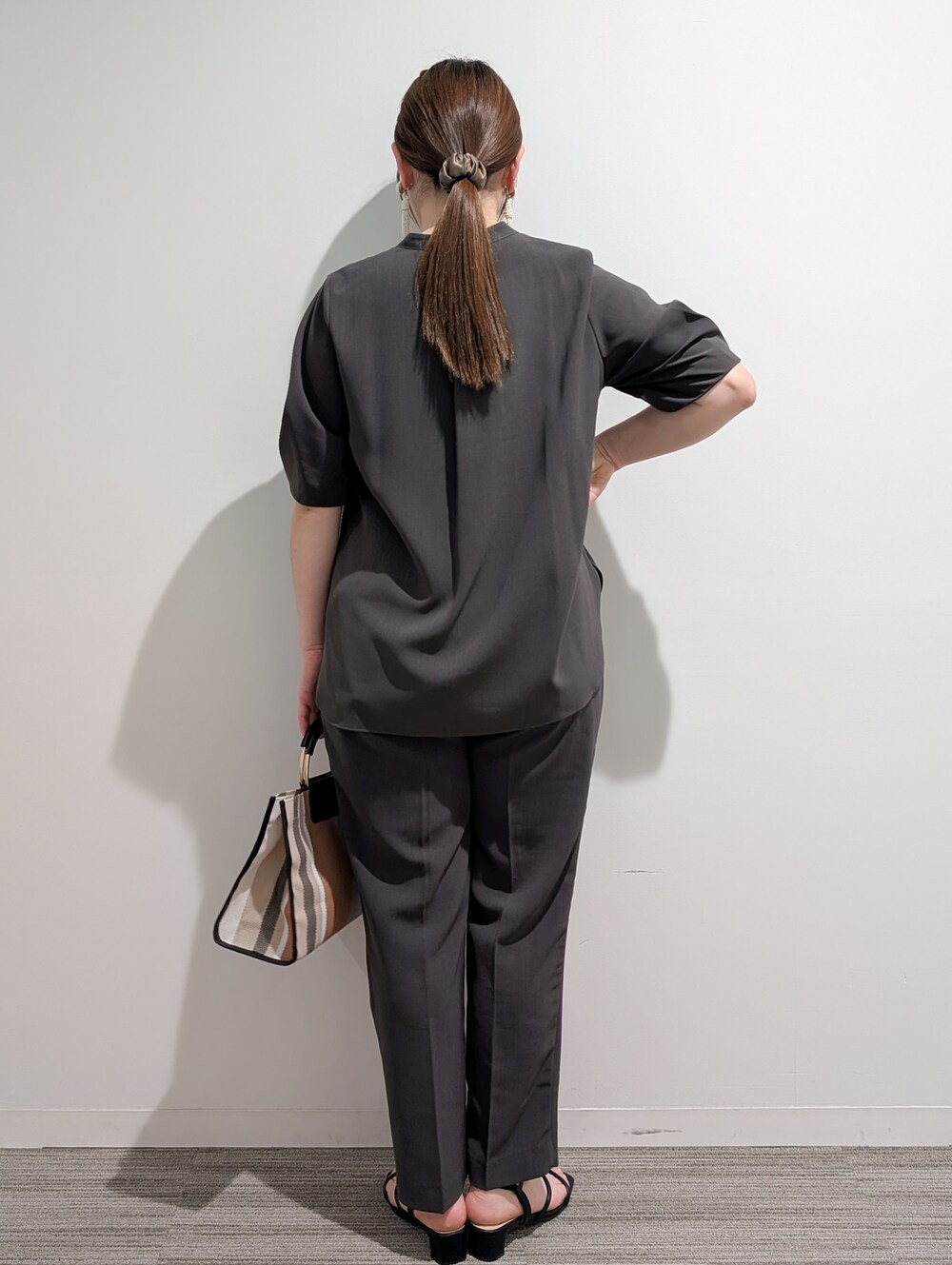 グレー系のシャツ/ブラウス、グレー系のその他パンツ、ブラック系のトートバッグを着用したレディースの春コーディネートの2枚目の写真