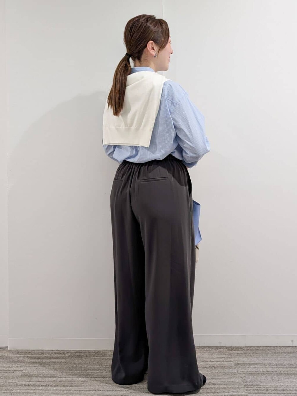 ブルー系のシャツ/ブラウス、ホワイト系のニット/セーター、グレー系のその他パンツを着用したレディースの冬コーディネートの4枚目の写真
