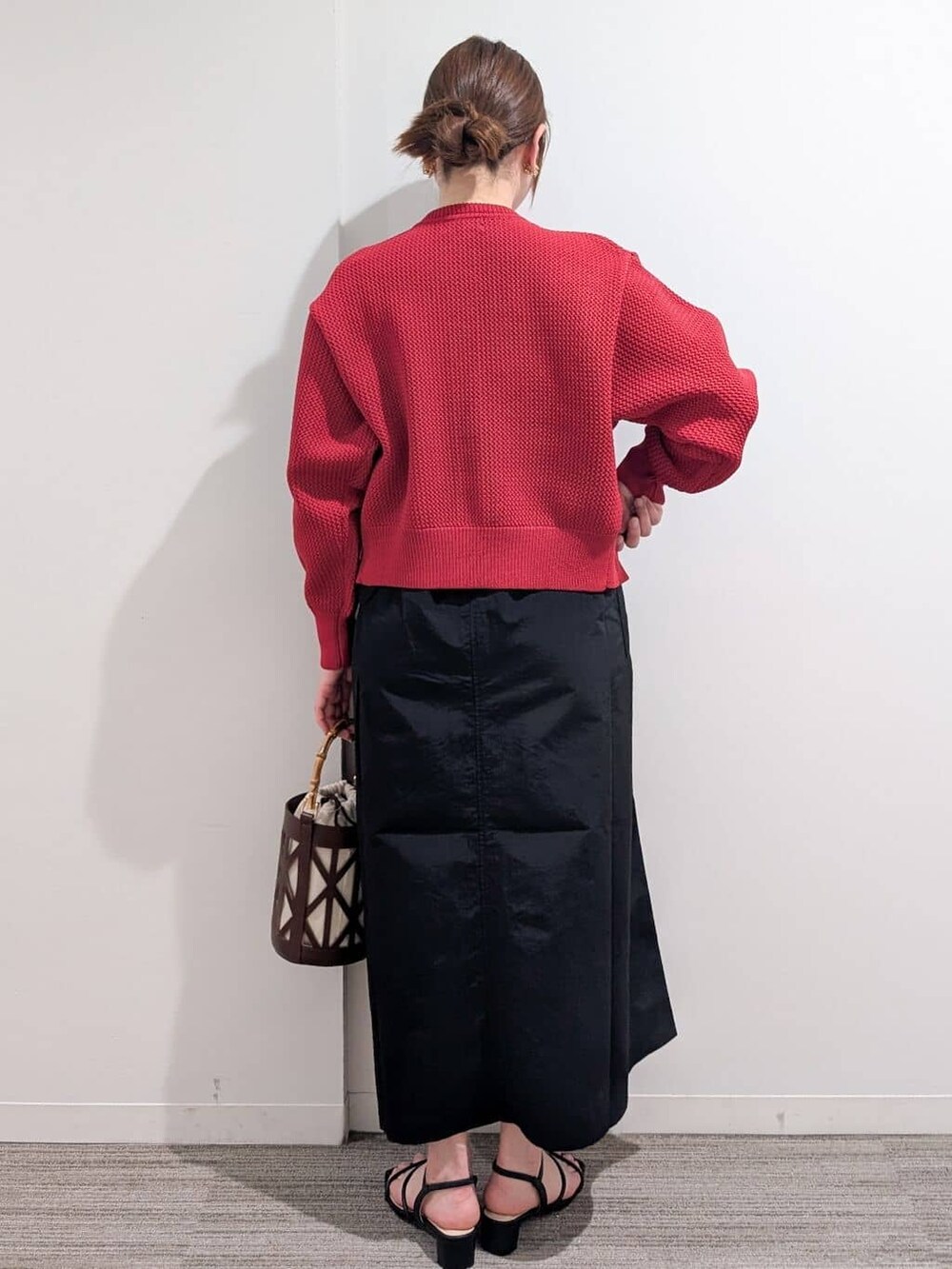 ブラック系のワンピース、レッド系のカーディガン/ボレロ、ブラック系のサンダルを着用したレディースの春コーディネートの8枚目の写真
