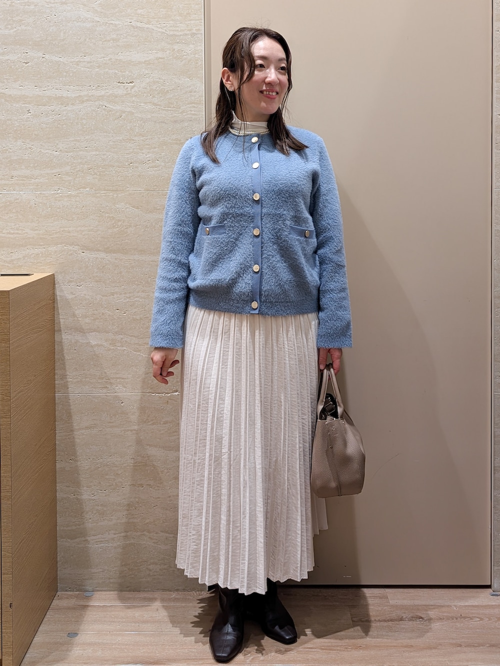 ブルー系のカーディガン/ボレロ、グレー系のスカート、ベージュ系のトートバッグを着用したレディースの秋コーディネートの10枚目の写真