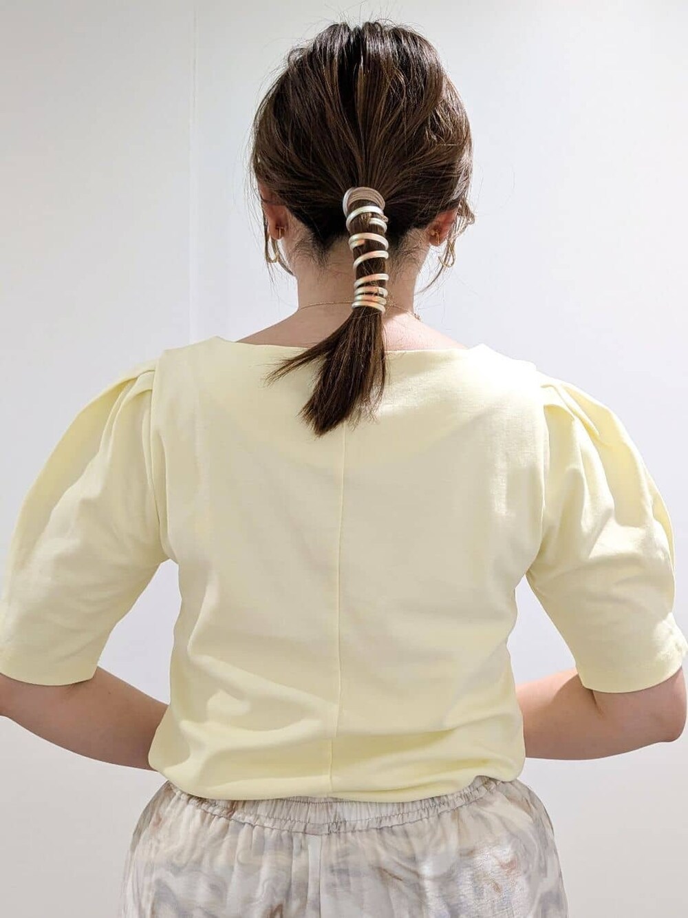 イエロー系のTシャツ/カットソー、グレー系のその他パンツ、ブラック系のハンドバッグを着用したレディースの夏コーディネートの9枚目の写真