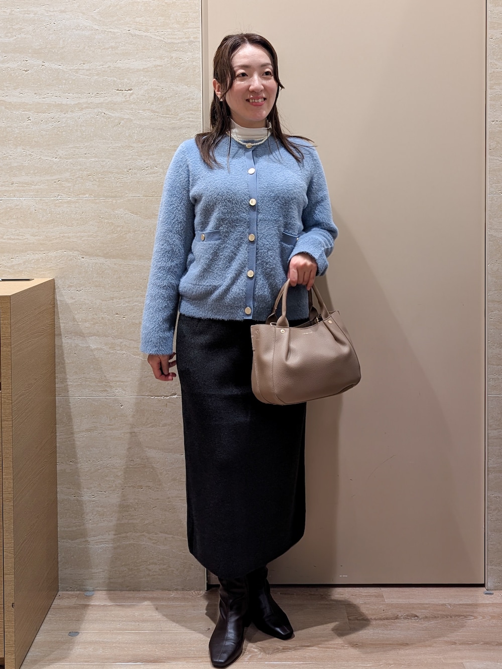 ブルー系のカーディガン/ボレロ、グレー系のスカート、ベージュ系のトートバッグを着用したレディースの秋コーディネートの9枚目の写真