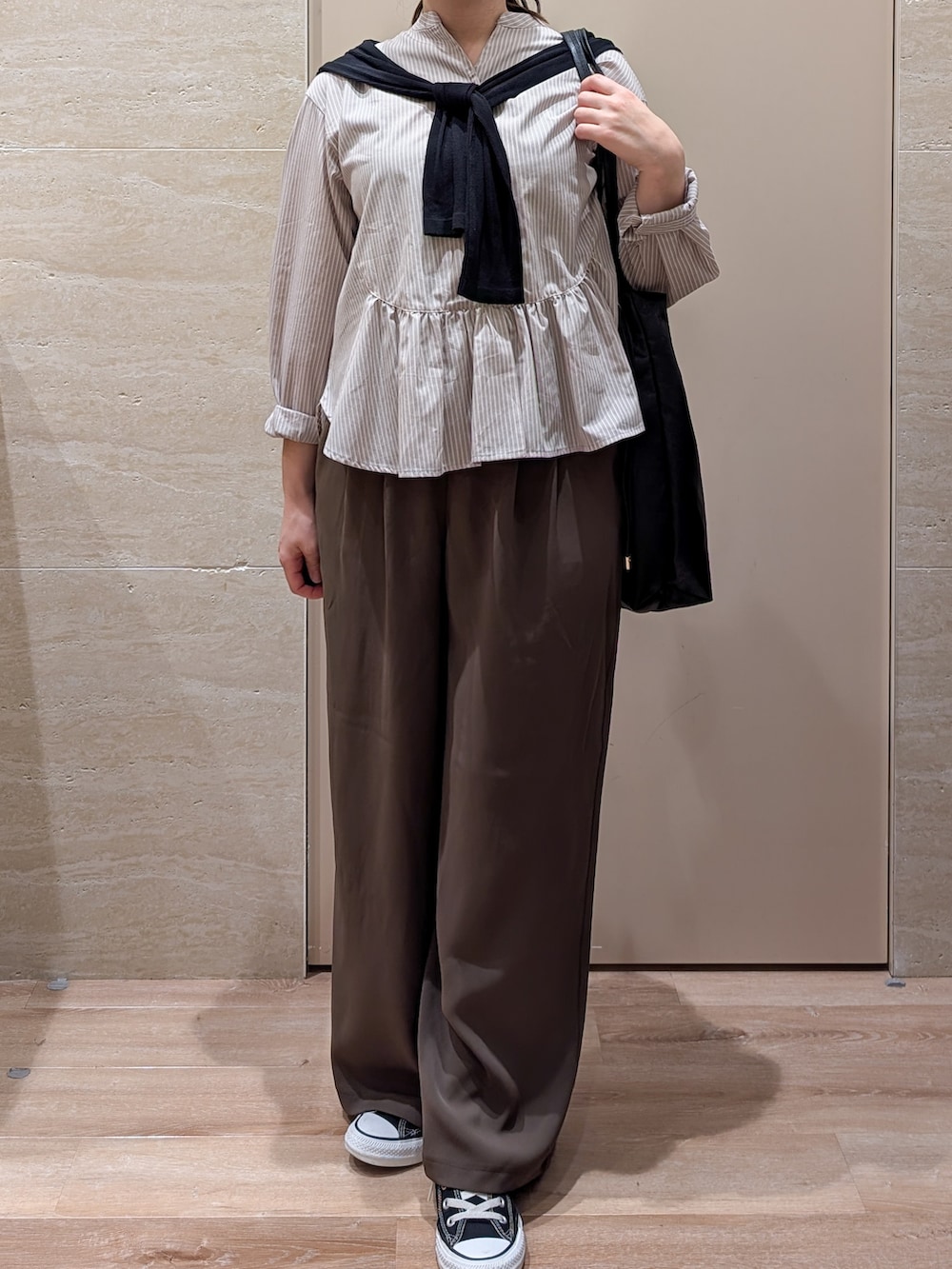 ベージュ系のシャツ/ブラウス、ブラウン系のその他パンツ、ブラック系のトートバッグを着用したレディースの秋コーディネートの3枚目の写真