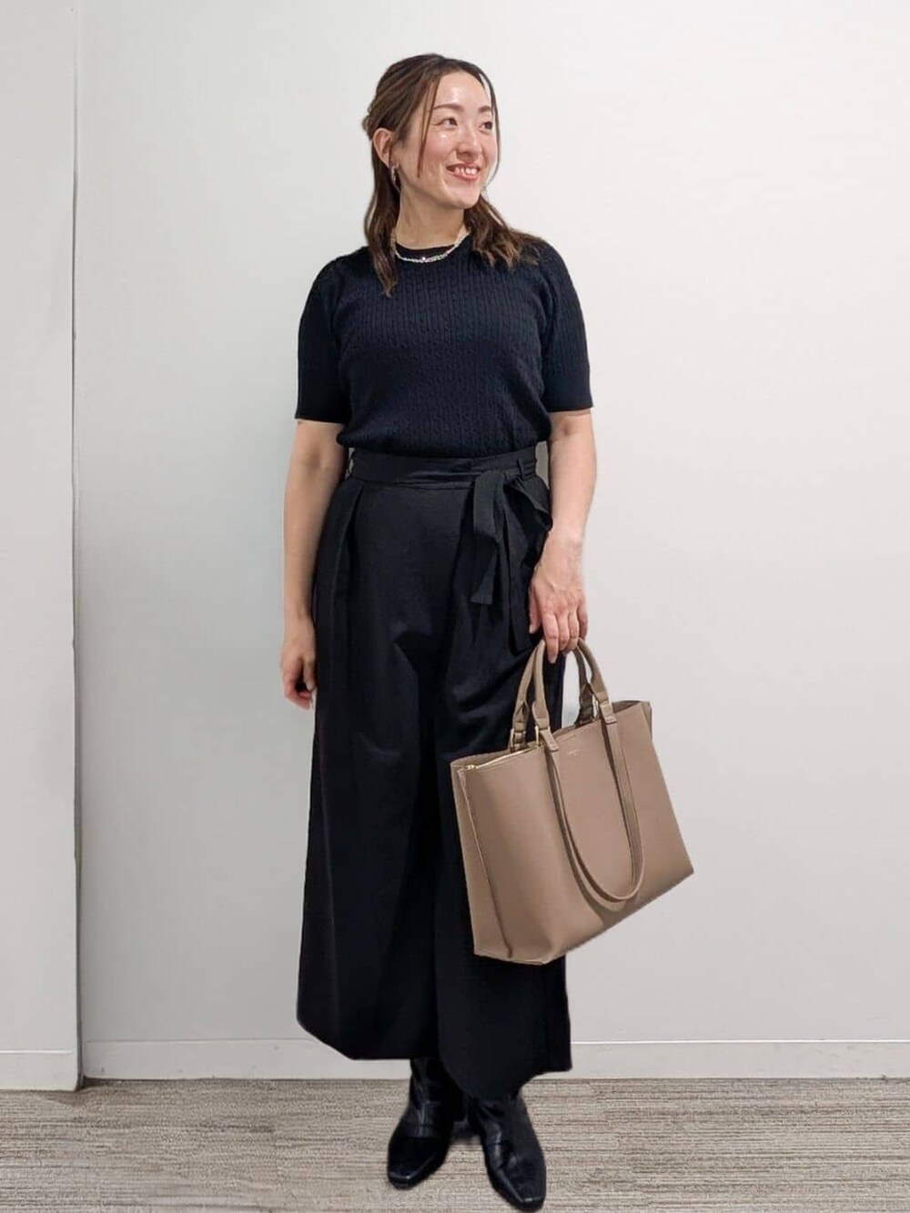 ブラック系のニット/セーター、ブラック系のその他パンツ、ベージュ系のトートバッグを着用したレディースの秋コーディネートの7枚目の写真