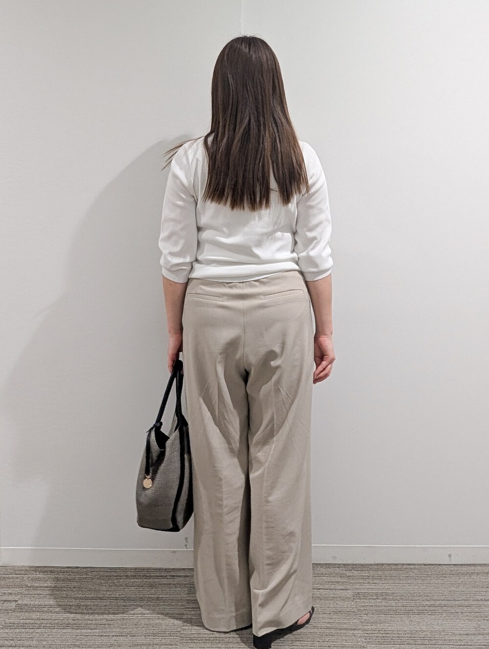 ホワイト系のニット/セーター、ベージュ系のその他パンツ、グレー系のトートバッグを着用したレディースの春コーディネートの6枚目の写真
