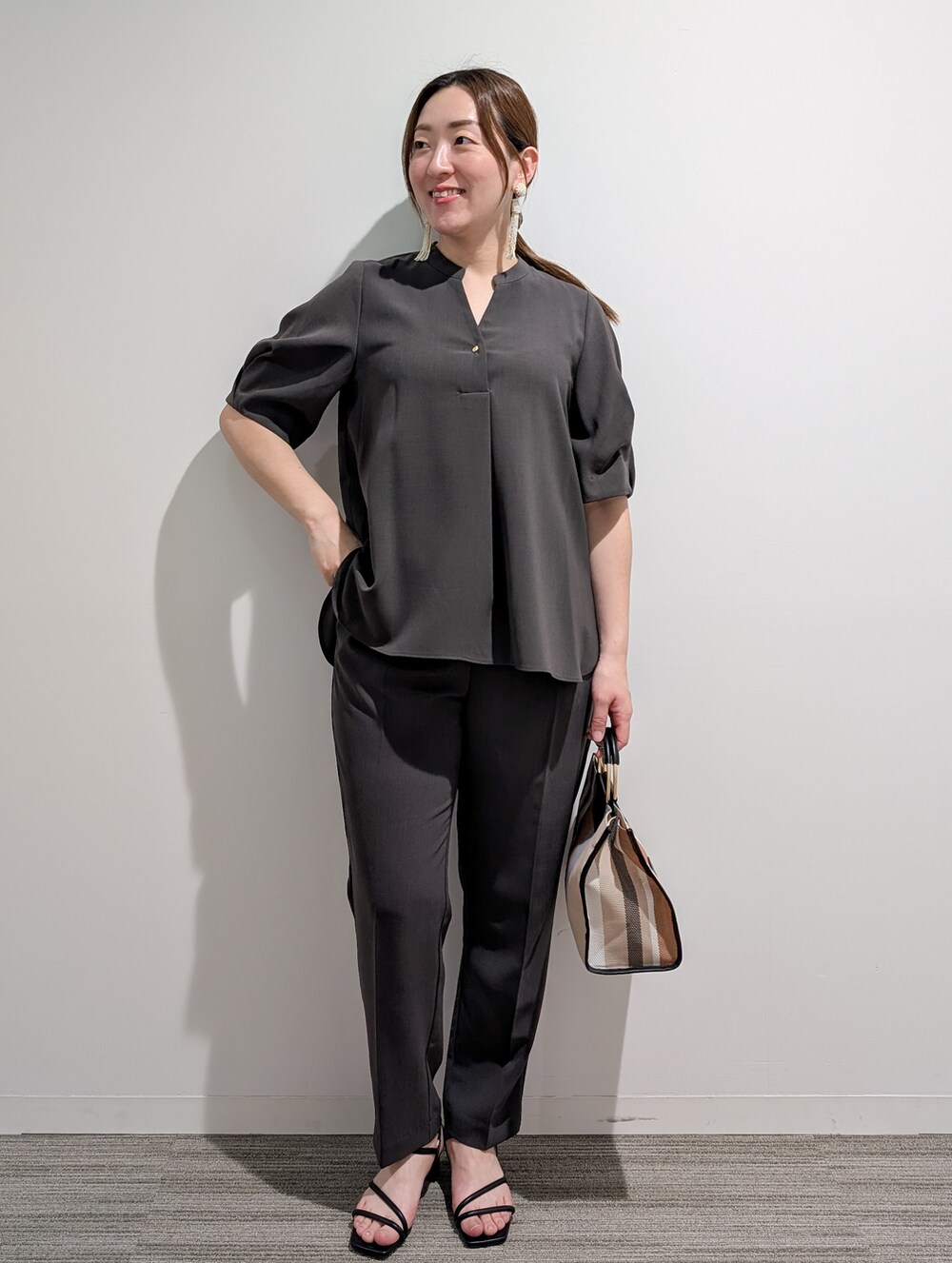 グレー系のシャツ/ブラウス、グレー系のその他パンツ、ブラック系のトートバッグを着用したレディースの春コーディネートの3枚目の写真