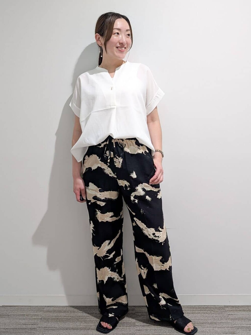 ホワイト系のシャツ/ブラウス、ブラック系のその他パンツ、ブラック系のサンダルを着用したレディースの夏コーディネートの2枚目の写真
