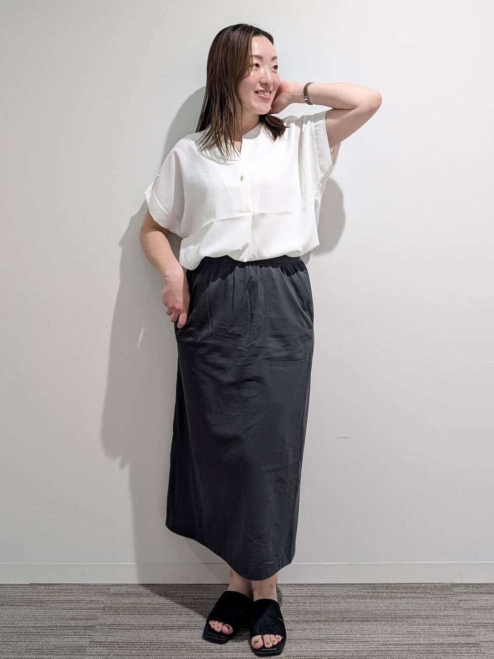 ホワイト系のシャツ/ブラウス、グレー系のスカート、ブラック系のサンダルを着用したレディースの夏コーディネートの4枚目の写真