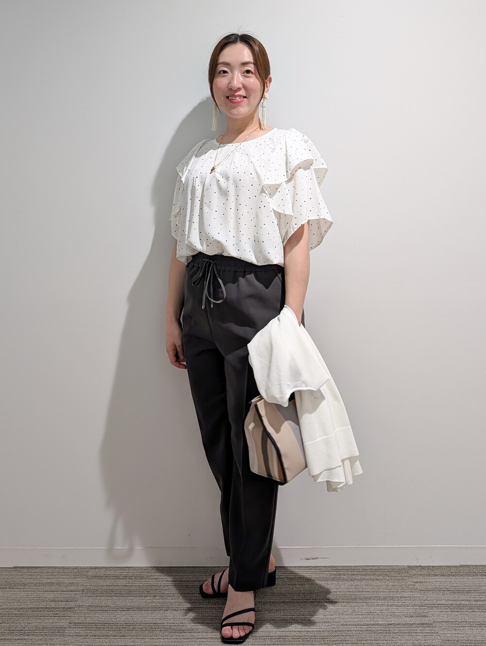 ホワイト系のシャツ/ブラウス、グレー系のその他パンツ、ブラック系のサンダルを着用したレディースの春コーディネートの8枚目の写真