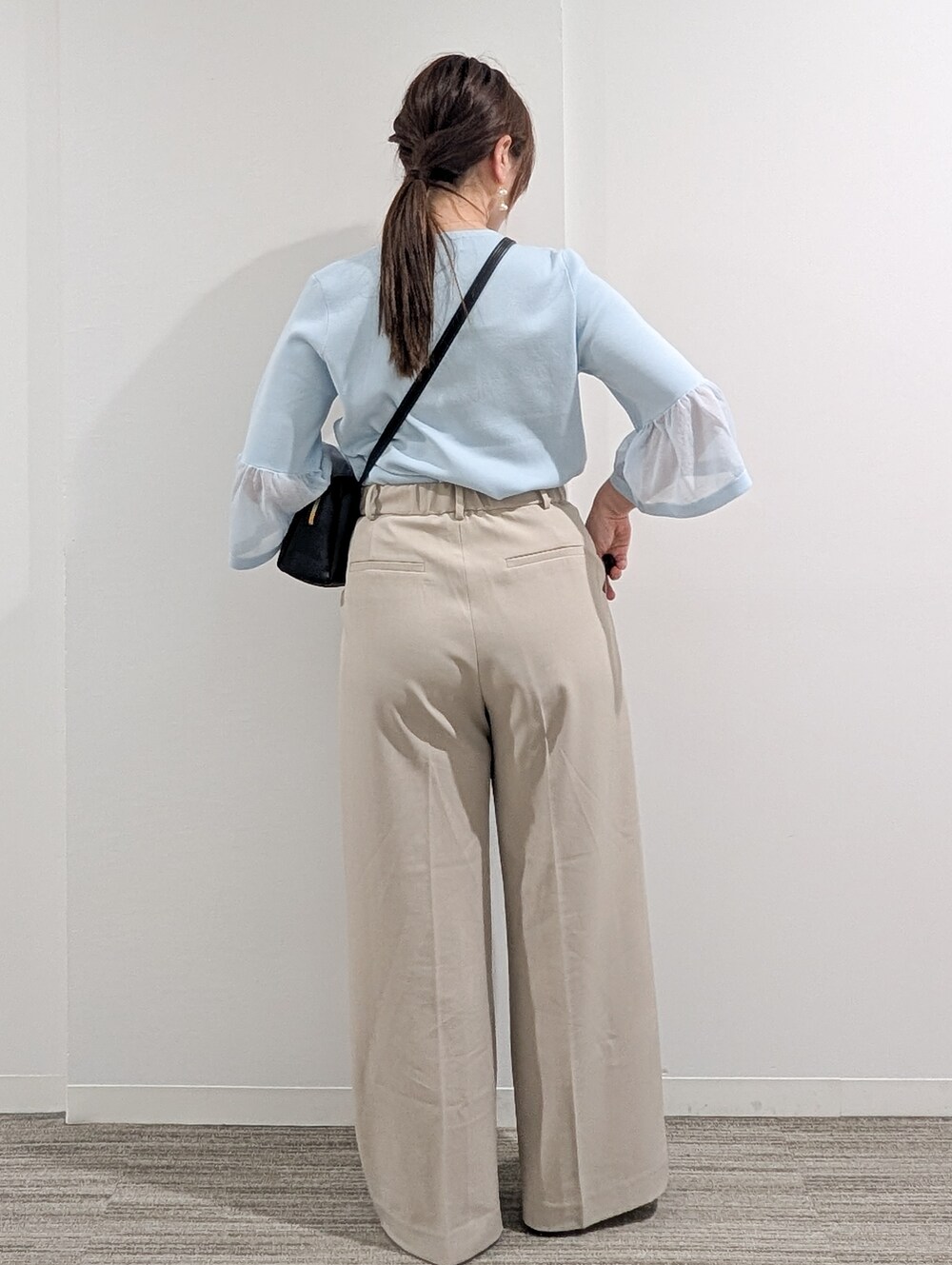 ブルー系のニット/セーター、ベージュ系のその他パンツ、ブラック系のショルダーバッグを着用したレディースの春コーディネートの5枚目の写真