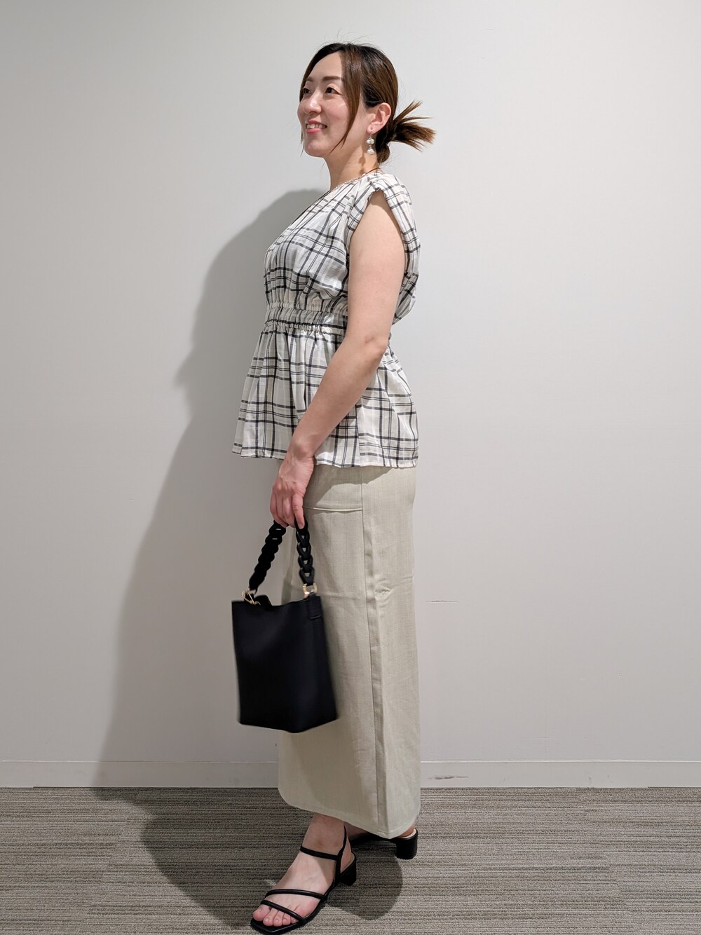 ベージュ系のシャツ/ブラウス、ベージュ系のスカート、ブラック系のショルダーバッグを着用したレディースの夏コーディネートの5枚目の写真