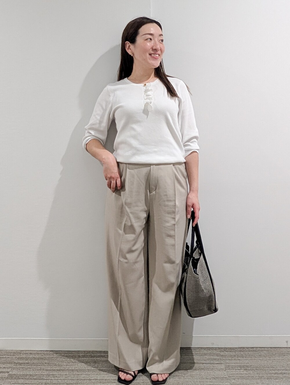 ホワイト系のニット/セーター、ベージュ系のその他パンツ、グレー系のトートバッグを着用したレディースの春コーディネートの4枚目の写真