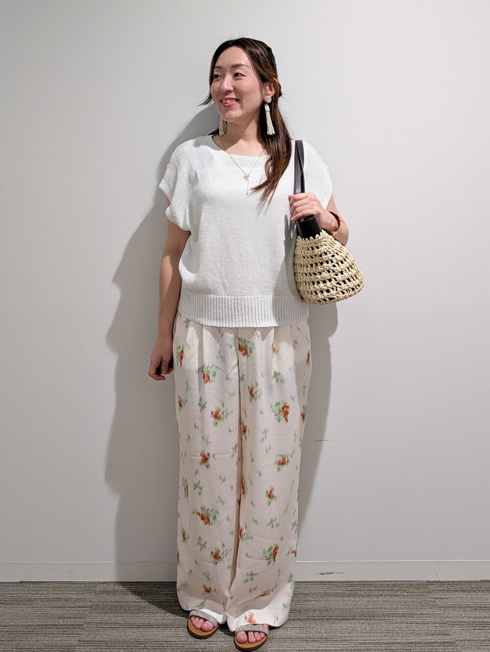 ホワイト系のニット/セーター、ホワイト系のその他パンツ、ブラウン系のトートバッグを着用したレディースの夏コーディネートの2枚目の写真