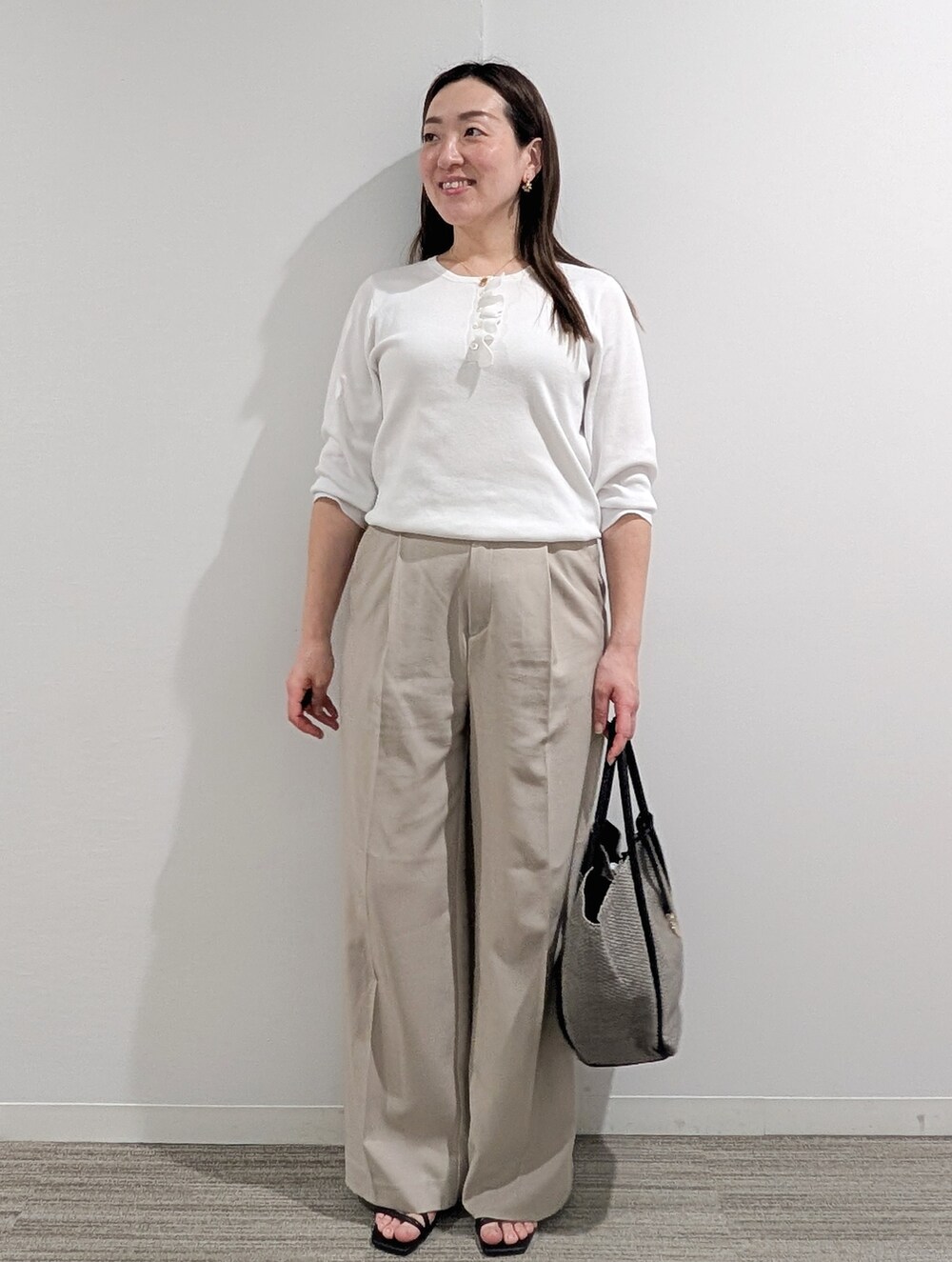ホワイト系のニット/セーター、ベージュ系のその他パンツ、グレー系のトートバッグを着用したレディースの春コーディネートの5枚目の写真