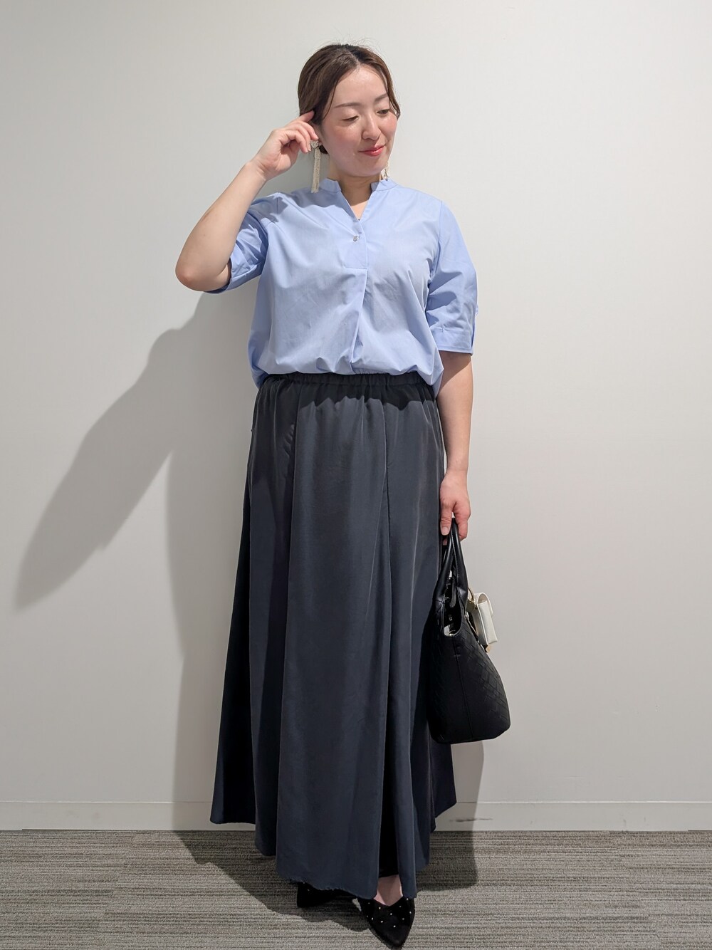 ブルー系のシャツ/ブラウス、グレー系のスカート、ブラック系のトートバッグを着用したレディースの夏コーディネートの9枚目の写真