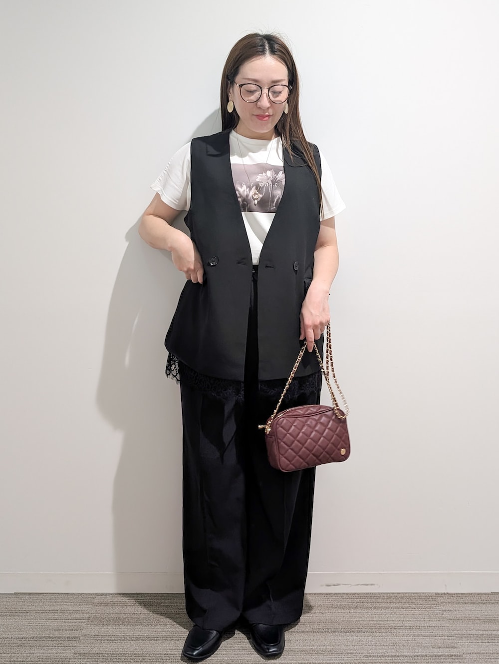 ブラック系のベスト、ホワイト系のTシャツ/カットソー、ブラック系のその他パンツを着用したレディースの秋コーディネートの2枚目の写真