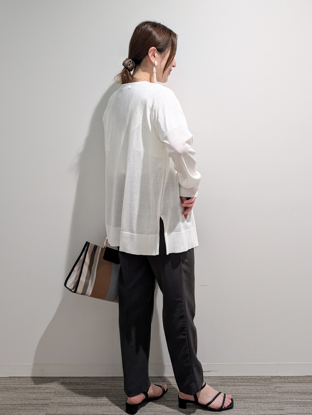 ホワイト系のシャツ/ブラウス、グレー系のその他パンツ、ブラック系のサンダルを着用したレディースの春コーディネートの4枚目の写真