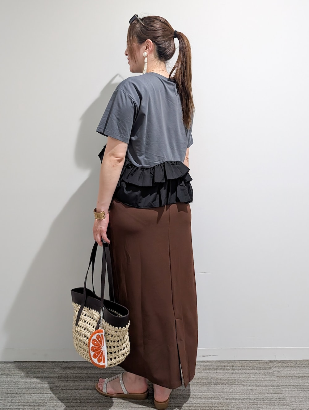 グレー系のTシャツ/カットソー、ブラウン系のスカート、ブラウン系のトートバッグを着用したレディースの夏コーディネートの4枚目の写真