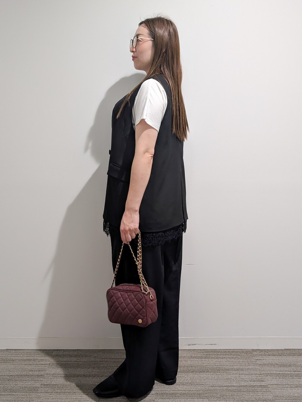 ブラック系のベスト、ホワイト系のTシャツ/カットソー、ブラック系のその他パンツを着用したレディースの秋コーディネートの4枚目の写真