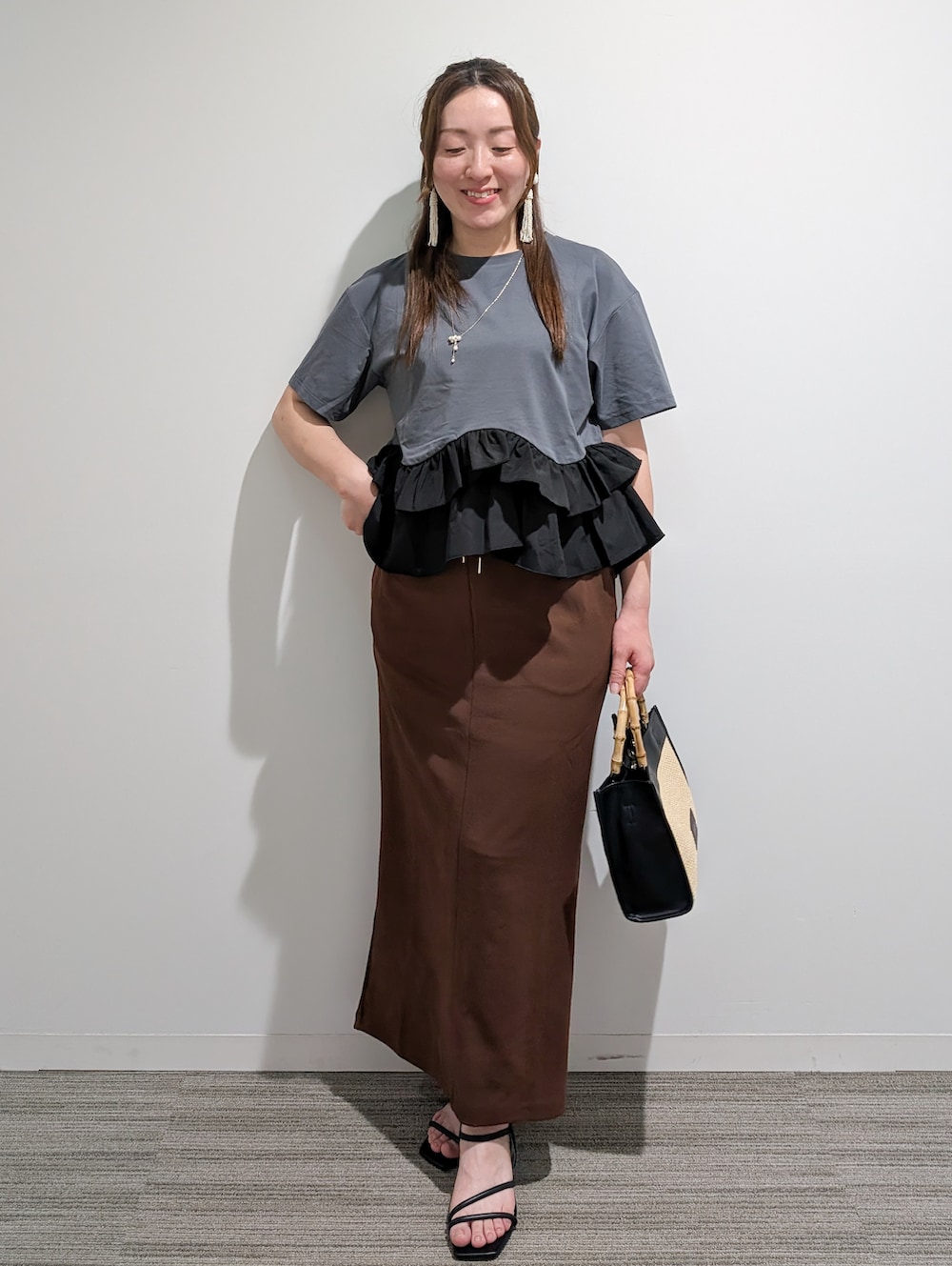 グレー系のTシャツ/カットソー、ブラウン系のスカート、ブラック系のトートバッグを着用したレディースの夏コーディネートの2枚目の写真