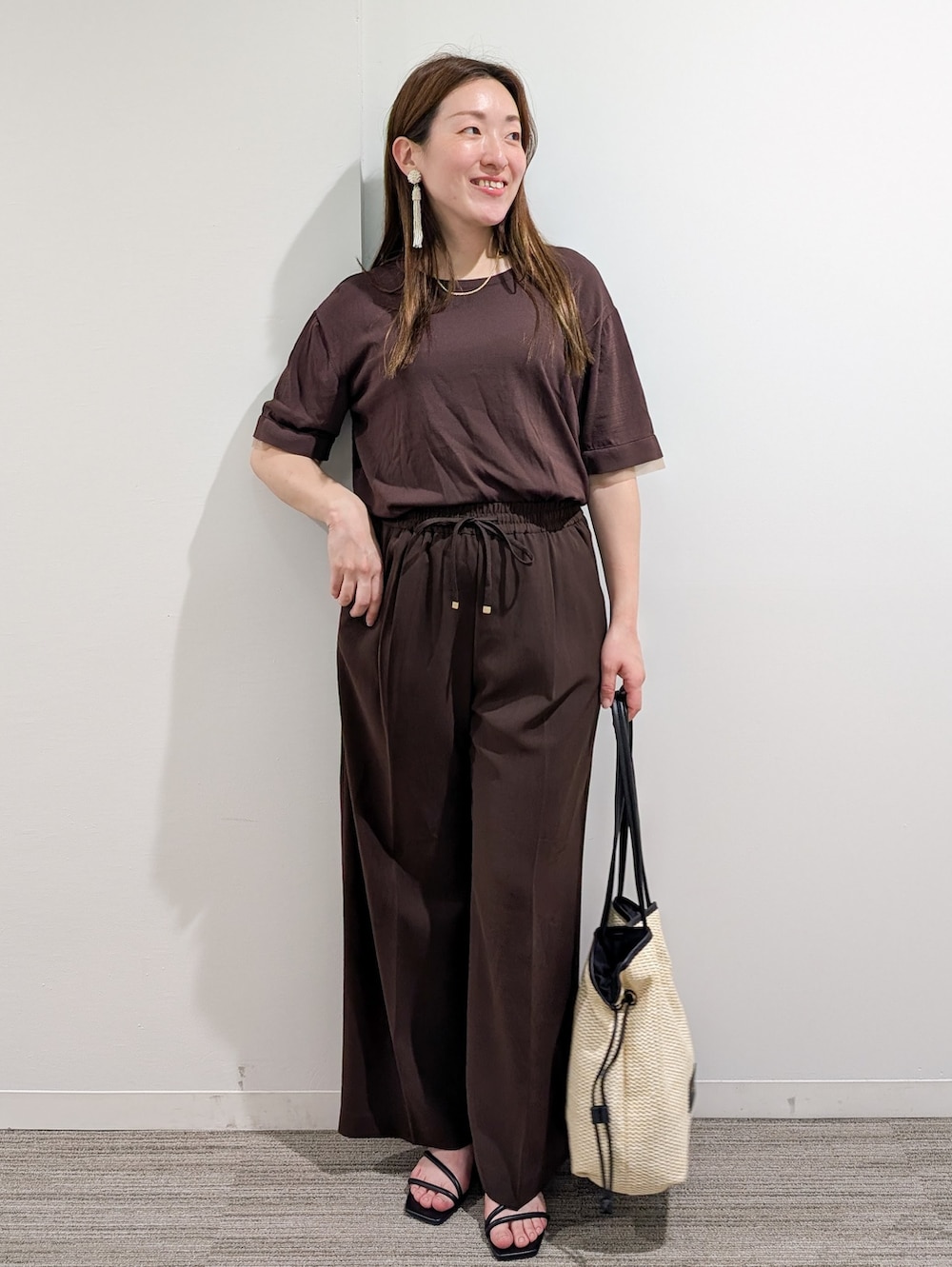 ブラウン系のニット/セーター、ブラウン系のその他パンツ、ホワイト系のトートバッグを着用したレディースの夏コーディネートの2枚目の写真