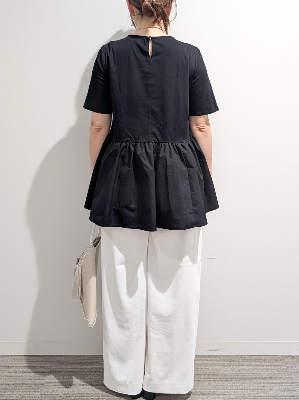ブラック系のTシャツ/カットソー、ホワイト系のその他パンツ、ホワイト系のハンドバッグを着用したレディースの夏コーディネートの4枚目の写真