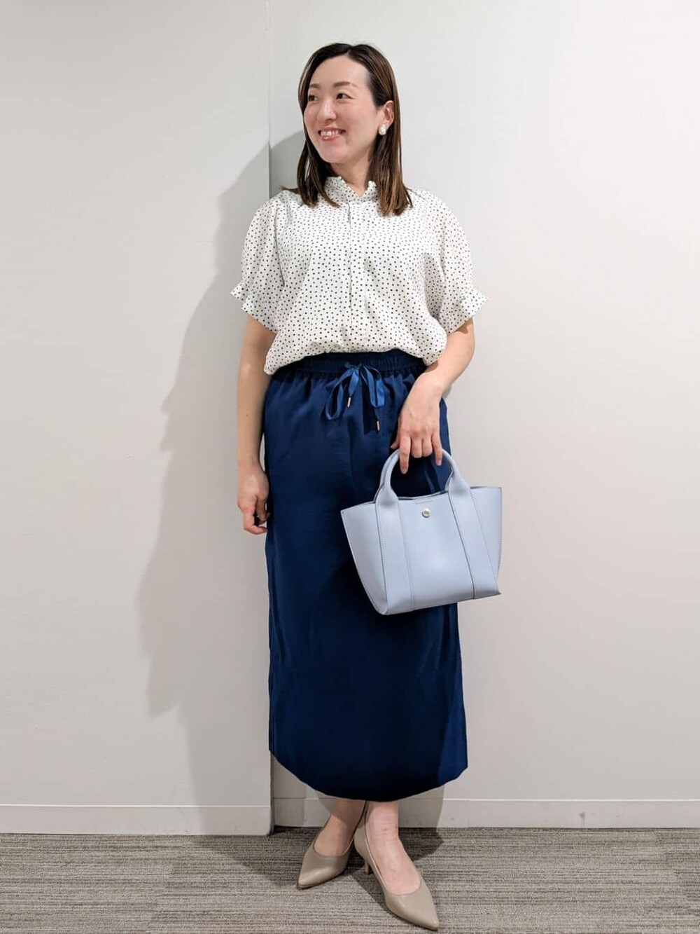 ホワイト系のシャツ/ブラウス、ブルー系のスカート、ブルー系のトートバッグを着用したレディースの夏コーディネートの9枚目の写真