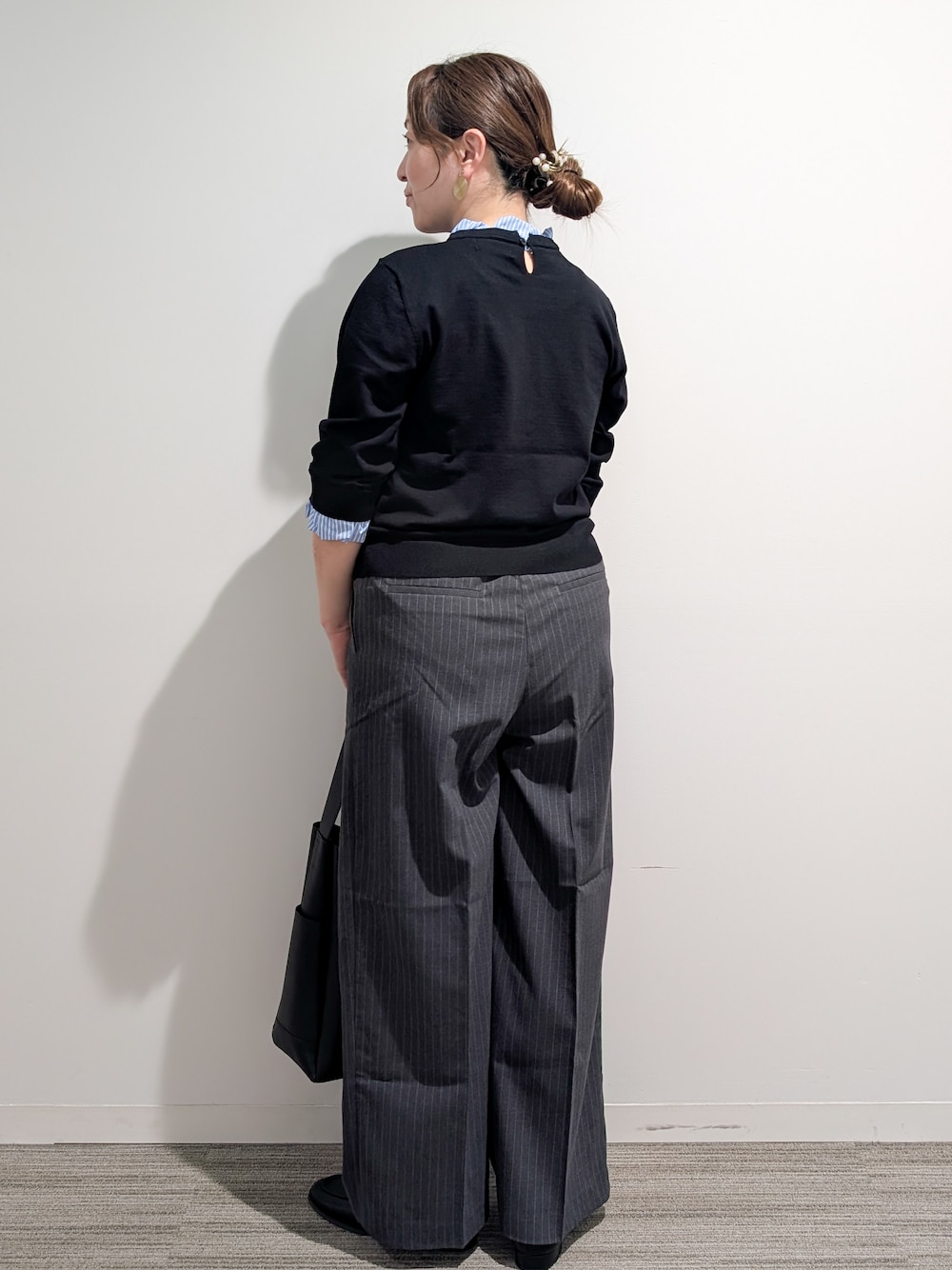 ブラック系のニット/セーター、グレー系のその他パンツ、ブラック系のトートバッグを着用したレディースの秋コーディネートの4枚目の写真