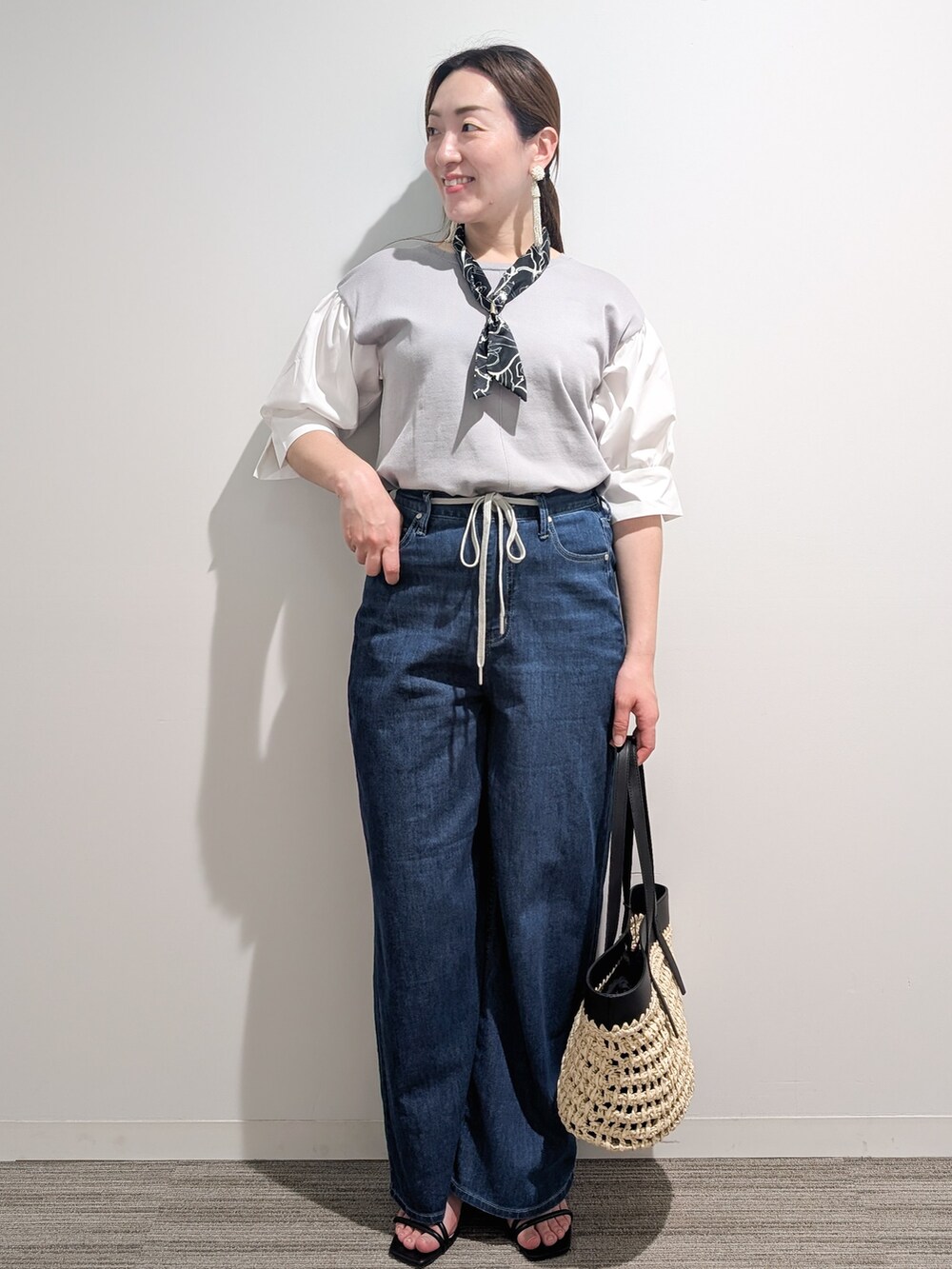 グレー系のニット/セーター、ブルー系のデニムパンツ、ブラック系のトートバッグを着用したレディースの夏コーディネートの8枚目の写真