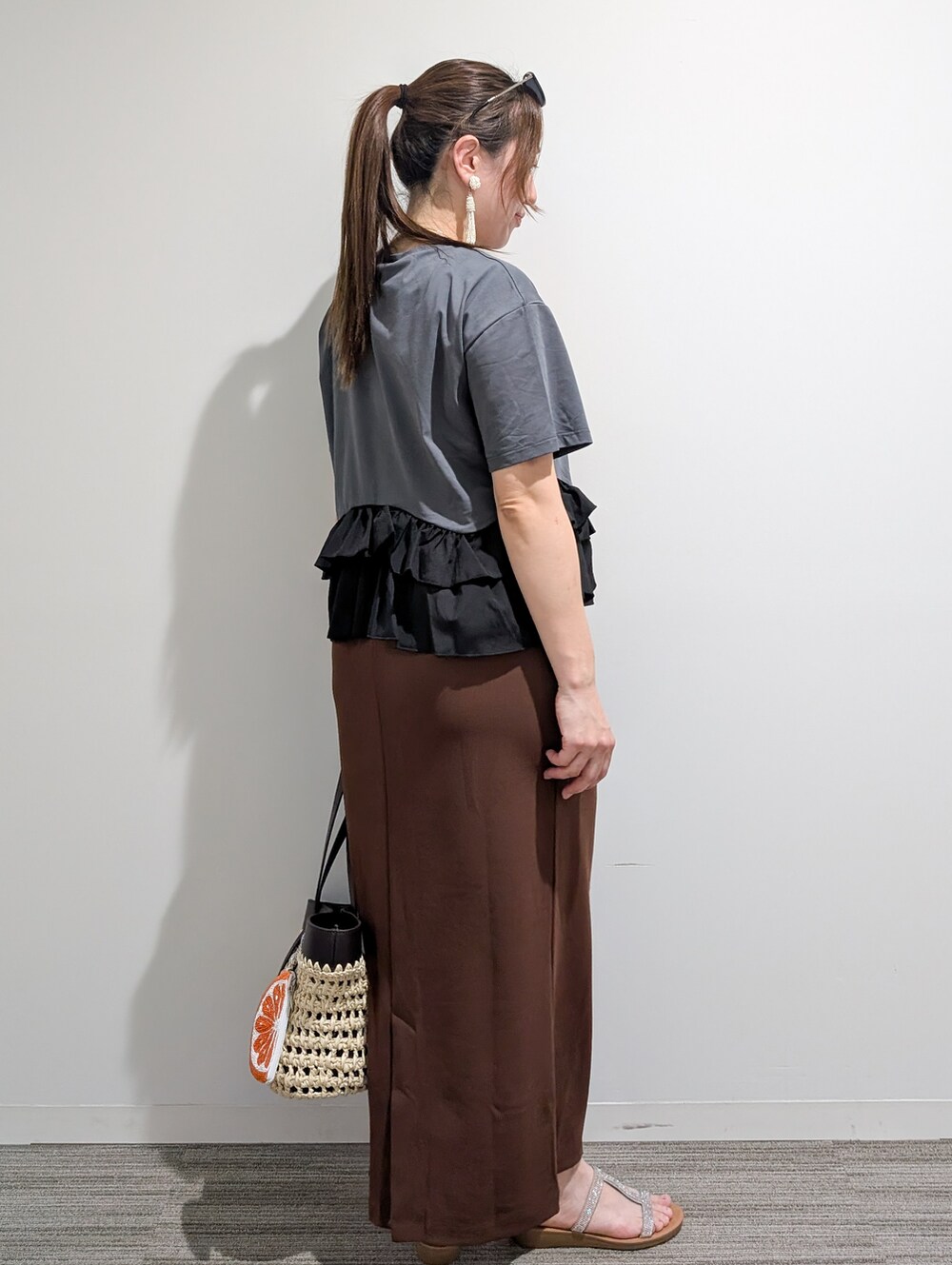 グレー系のTシャツ/カットソー、ブラウン系のスカート、ブラウン系のトートバッグを着用したレディースの夏コーディネートの6枚目の写真