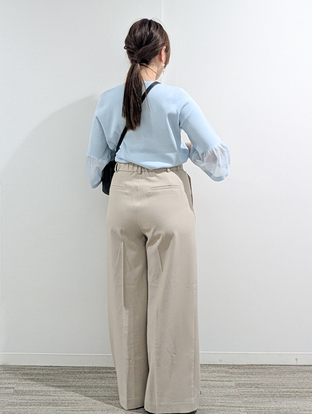 ブルー系のニット/セーター、ベージュ系のその他パンツ、ブラック系のショルダーバッグを着用したレディースの春コーディネートの6枚目の写真