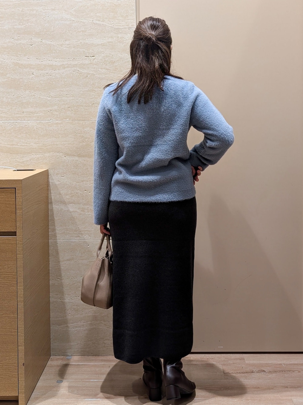 ブルー系のカーディガン/ボレロ、グレー系のスカート、ベージュ系のトートバッグを着用したレディースの秋コーディネートの4枚目の写真