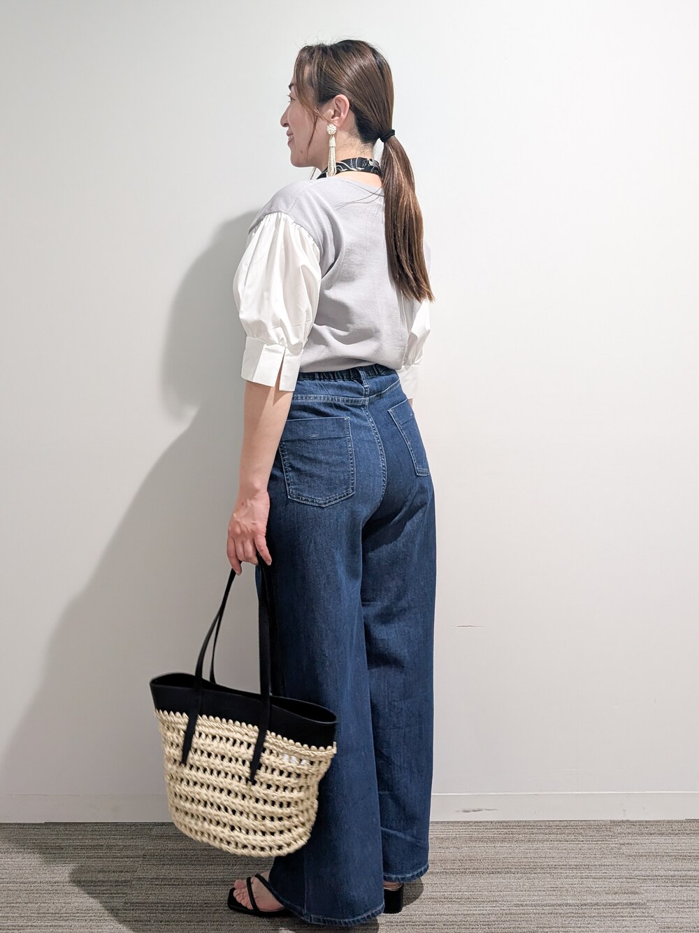 グレー系のニット/セーター、ブルー系のデニムパンツ、ブラック系のトートバッグを着用したレディースの夏コーディネートの3枚目の写真