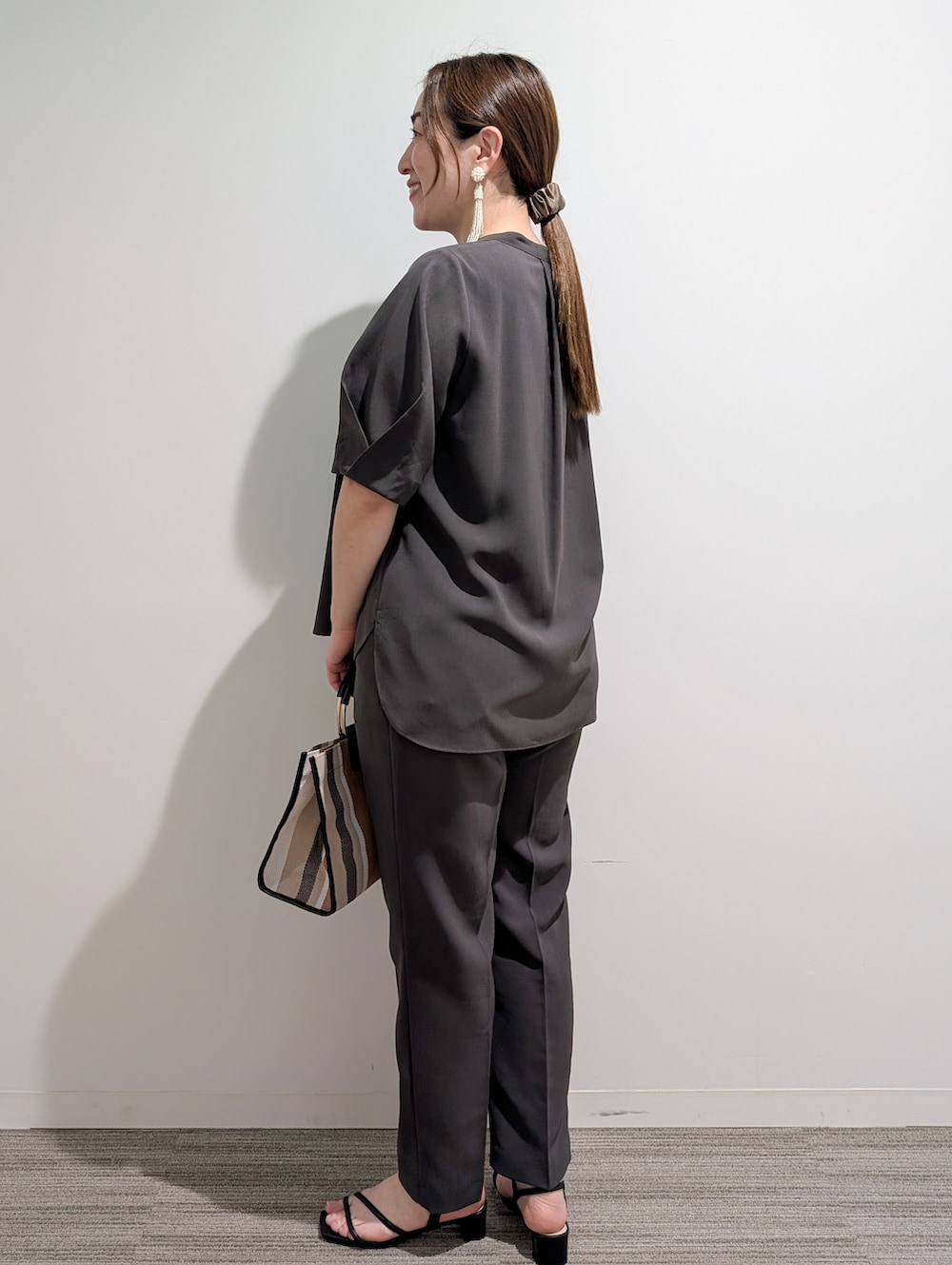 グレー系のシャツ/ブラウス、グレー系のその他パンツ、ブラック系のトートバッグを着用したレディースの春コーディネートの6枚目の写真