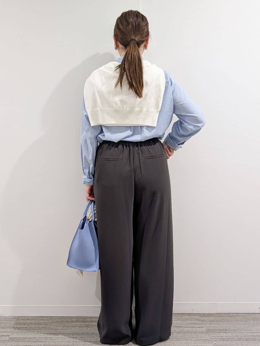 ブルー系のシャツ/ブラウス、ホワイト系のニット/セーター、グレー系のその他パンツを着用したレディースの冬コーディネートの5枚目の写真