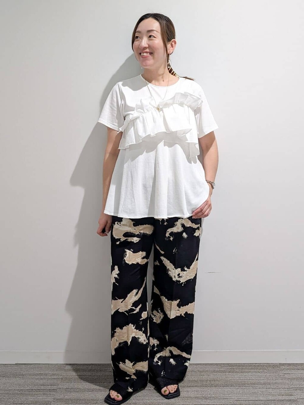 ホワイト系のTシャツ/カットソー、ブラック系のその他パンツ、ブラック系のサンダルを着用したレディースの夏コーディネートの3枚目の写真
