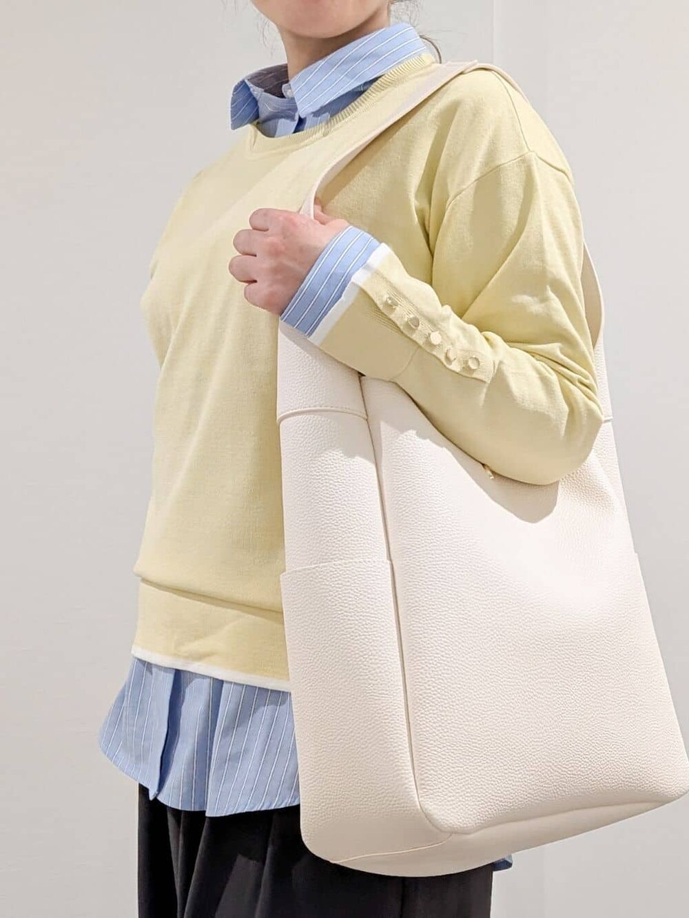 イエロー系のニット/セーター、ブルー系のシャツ/ブラウス、グレー系のその他パンツを着用したレディースの冬コーディネートの7枚目の写真