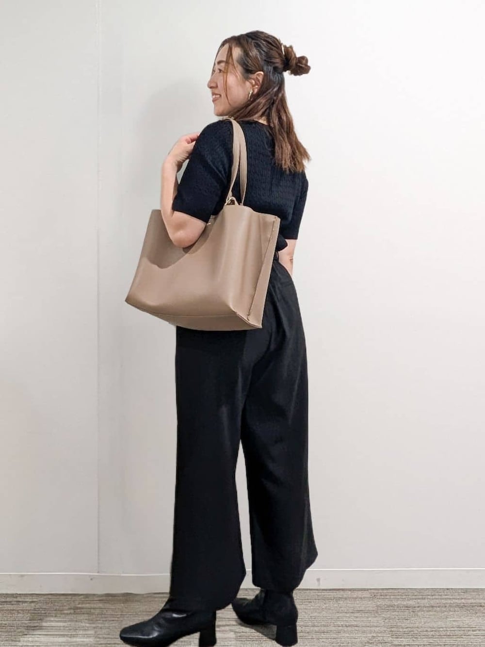 ブラック系のニット/セーター、ブラック系のその他パンツ、ベージュ系のトートバッグを着用したレディースの秋コーディネートの2枚目の写真