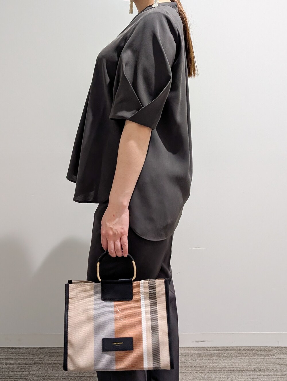 グレー系のシャツ/ブラウス、グレー系のその他パンツ、ブラック系のトートバッグを着用したレディースの春コーディネートの7枚目の写真
