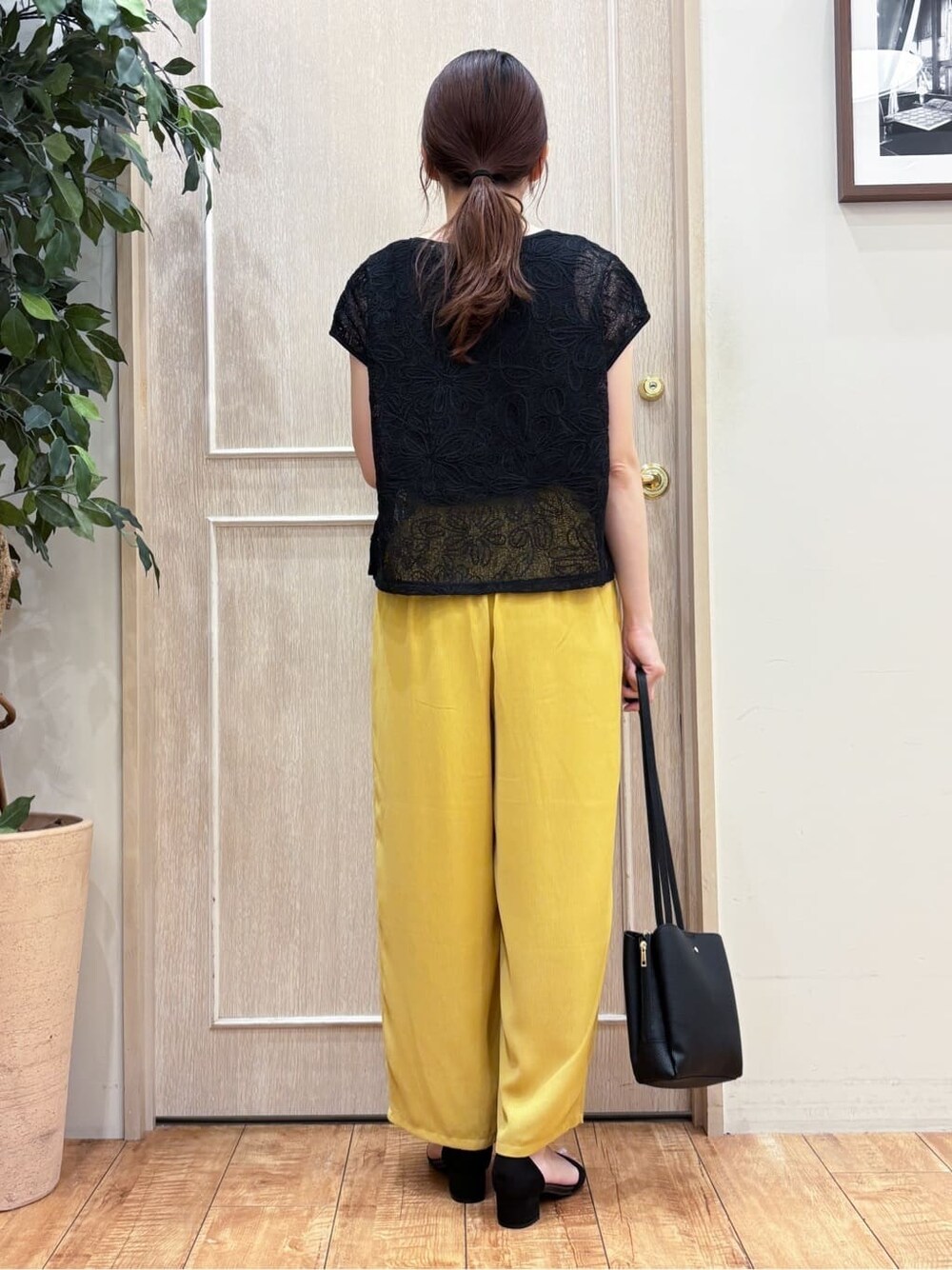 ブラック系のその他トップス、イエロー系のその他パンツ、ブラック系のサンダルを着用したレディースの夏コーディネートの3枚目の写真