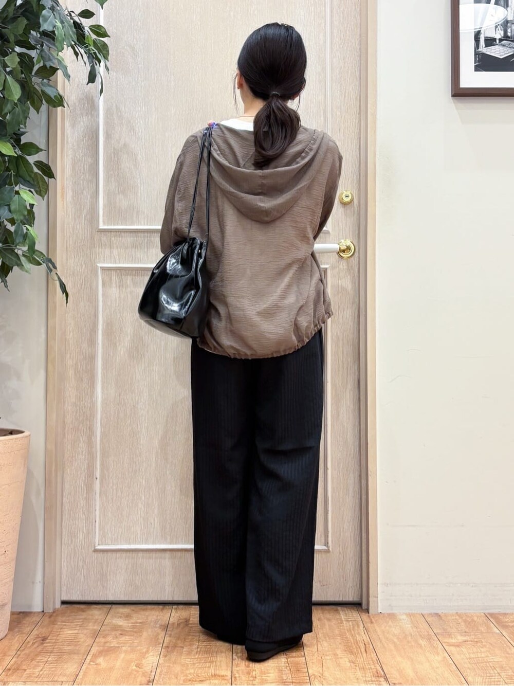 ブラウン系のブルゾン、ホワイト系のTシャツ/カットソー、ブラック系のその他パンツを着用したレディースの夏コーディネートの3枚目の写真